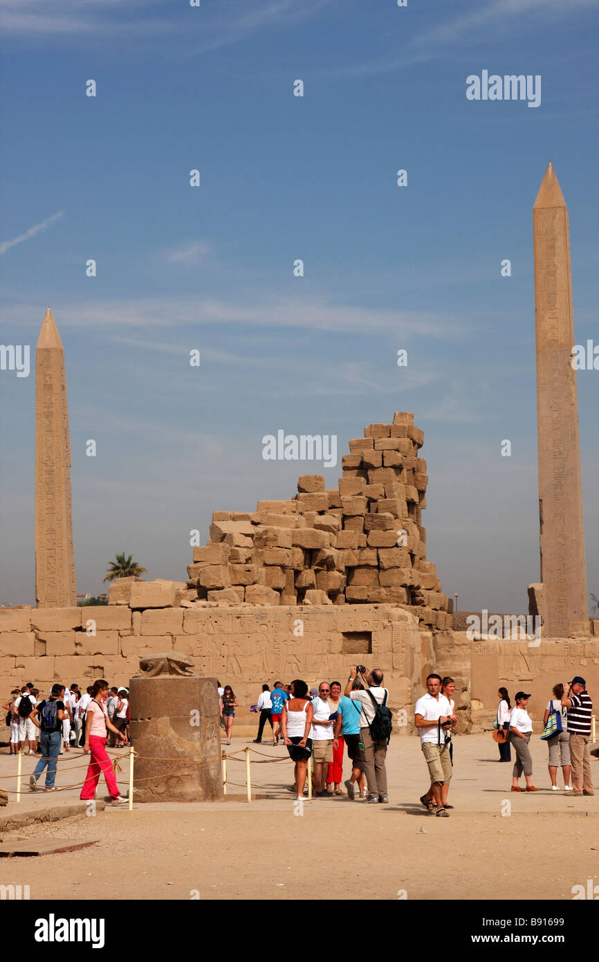 Karnak Temple ruins, Luxor, Egypt. Tourists, scarab beetle statue and obelisks of Pharaoh Tuthmosis I and Queen Hatshepsut Stock Photo