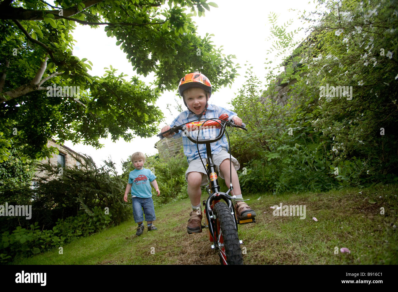 Two boys playing in a garden Stock Photo - Alamy