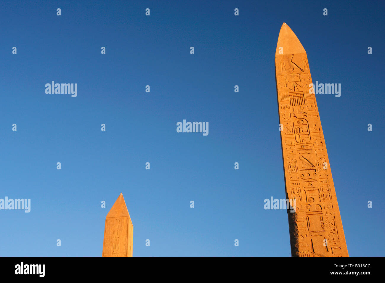 Obelisks of Queen Hatshepsut and Pharaoh Tuthmosis I carved with hieroglyphics against blue sky, Karnak Temple, Luxor, Egypt Stock Photo