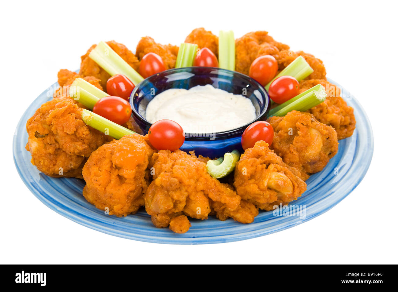 Spicy buffalo wings on platter with celery blue cheese dressing