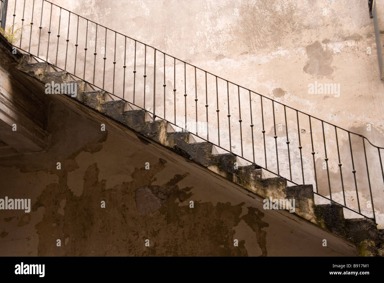 A flight of stairs, with a metal rail and peeling paint. Stock Photo
