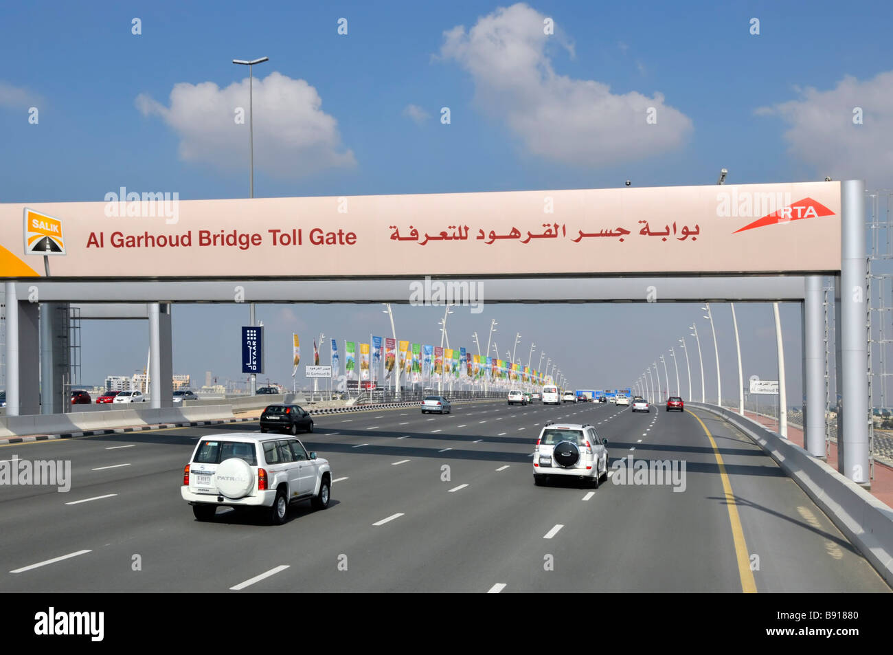 Dubai car traffic on modern seven lane motorways and RTA gantry signs leading to the Al Garhoud Bridge Toll Gate United Arab Emirates UAE Middle East Stock Photo