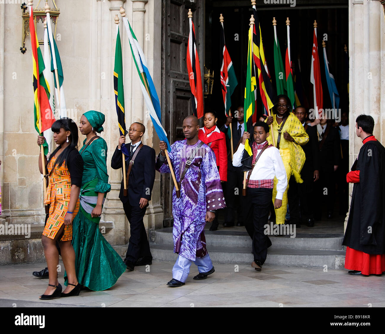 Young people carrying the flags of the Commonwealth depart Westminster Abbey in London after the Commonwealth Day Observance Ser Stock Photo