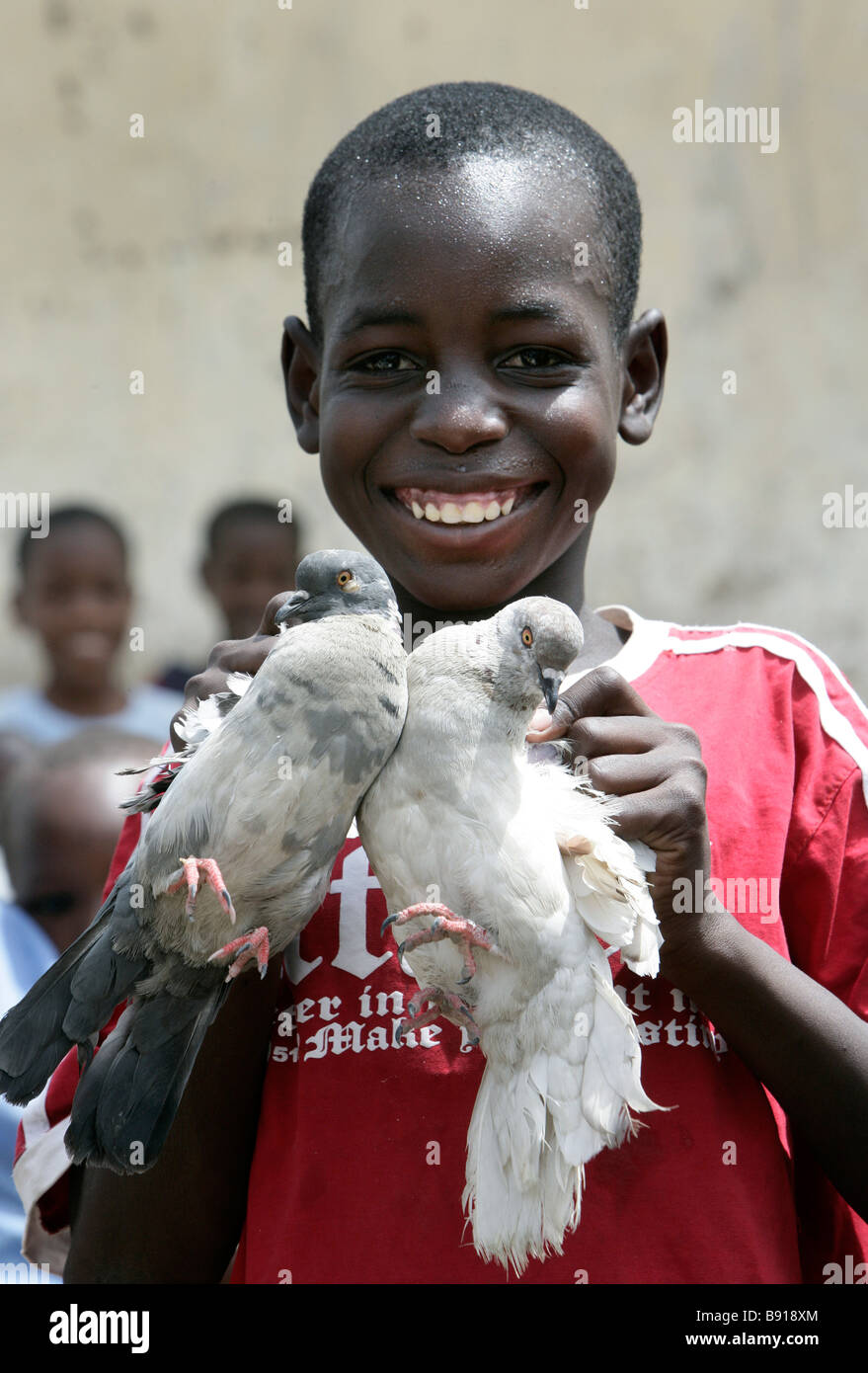 Nigeria: boy with two white pigeons Stock Photo