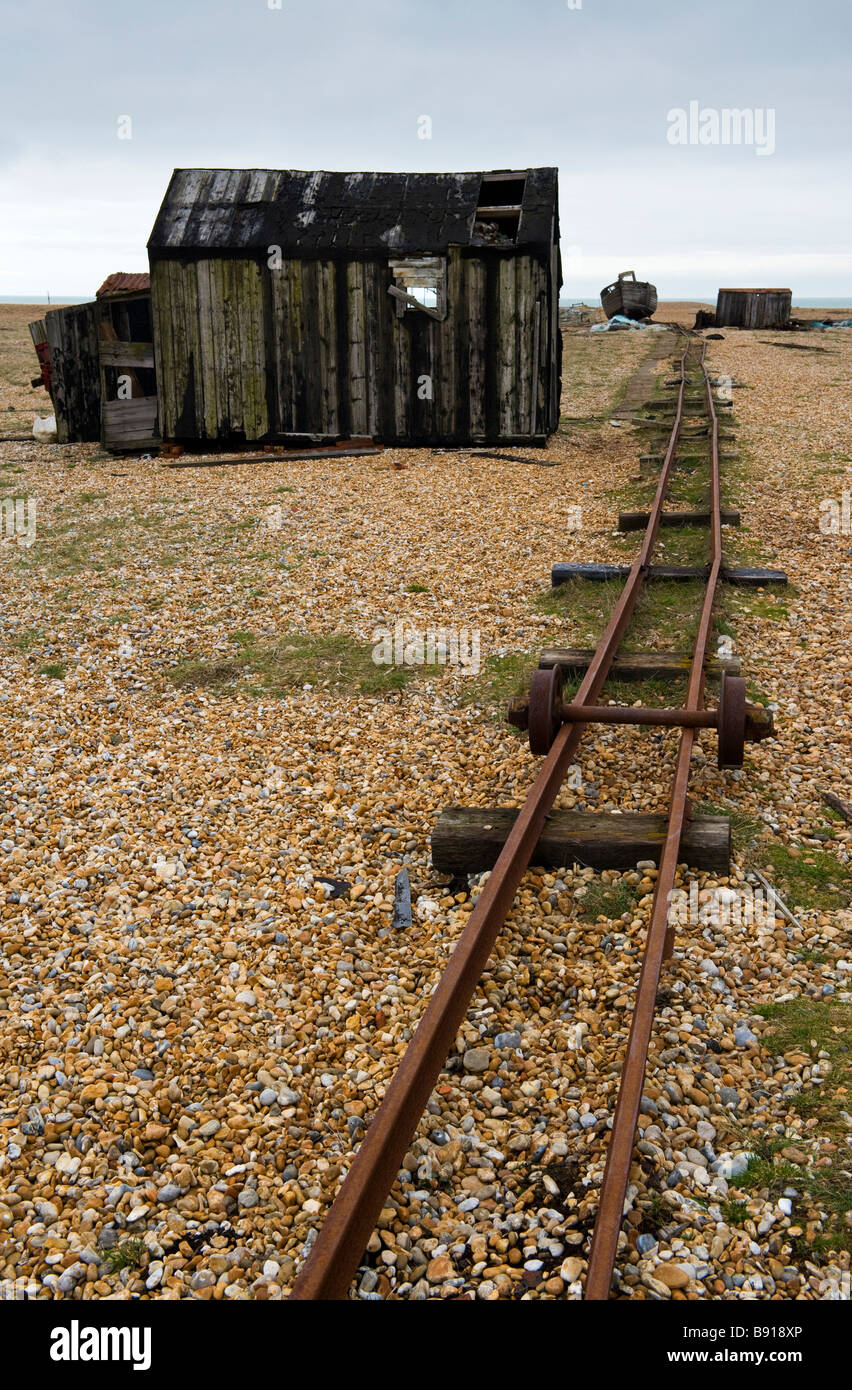An abandoned shed and rusty disused railway track on Dungeness shingle beach in Kent, UK Stock Photo