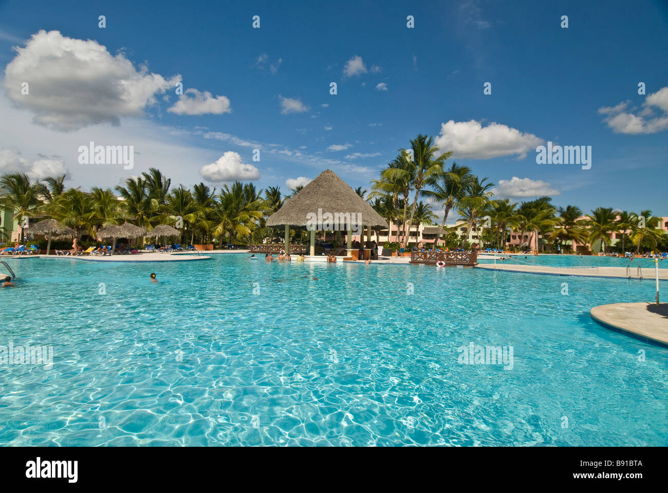 Hotel swimming pool thatch pool bar Bayahibe Dominican Republic Viva Wyndham Dominicus Palace all-inclusive resort palm trees Stock Photo