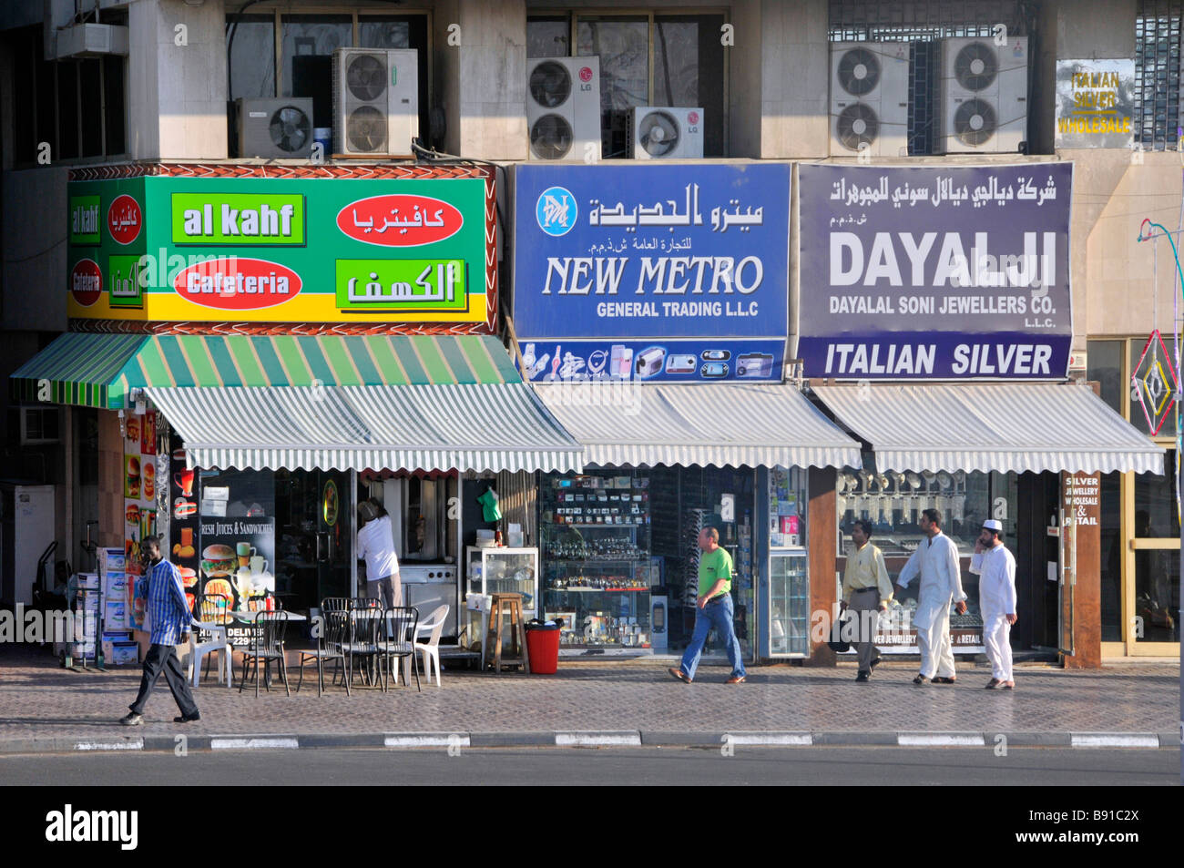Dubai typical shopping street scene includes silver jewellers shops and cafeteria premises air conditioning units above united arab emirates UAE Stock Photo