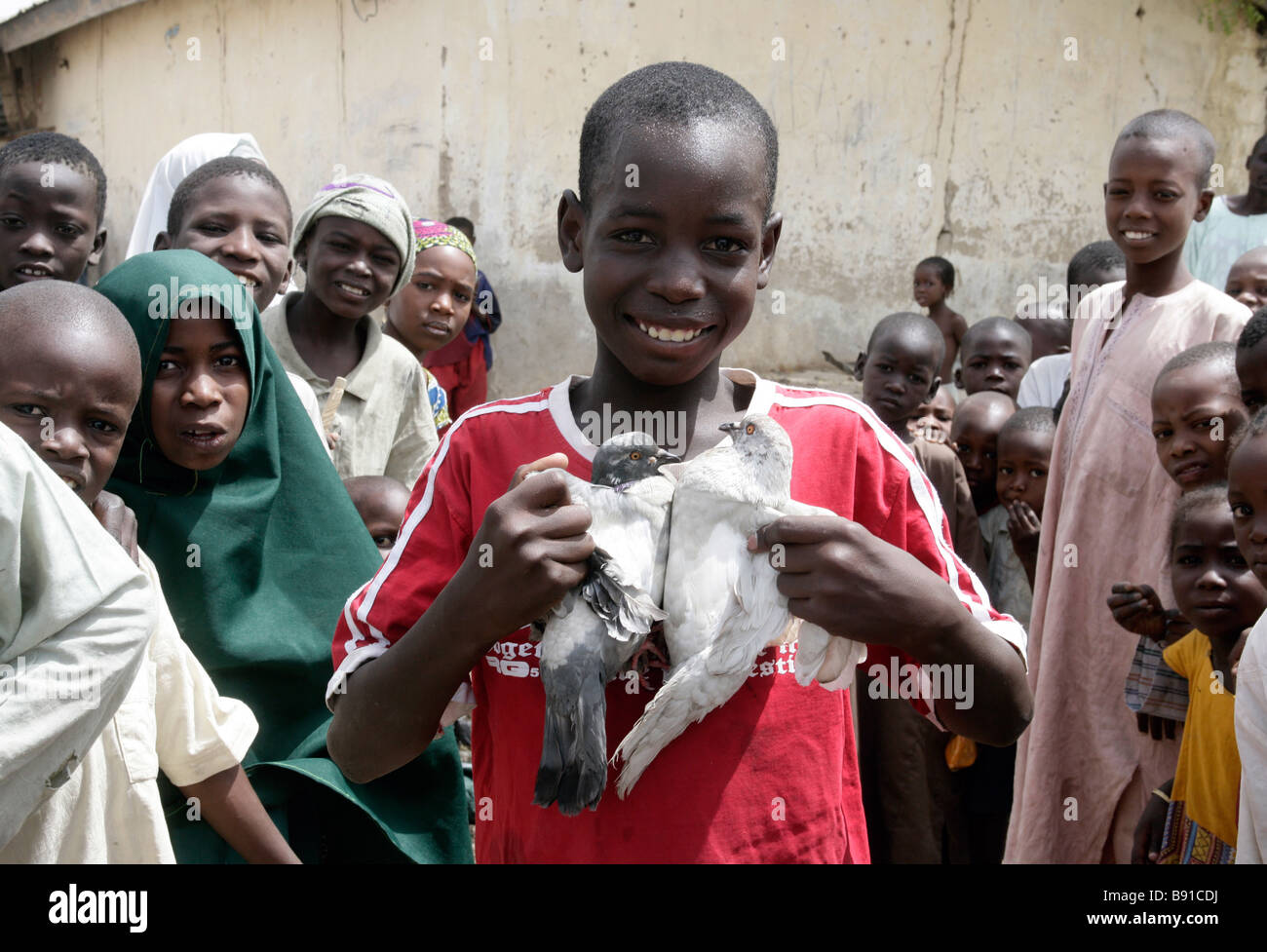 Nigeria: boy with two white pigeons Stock Photo