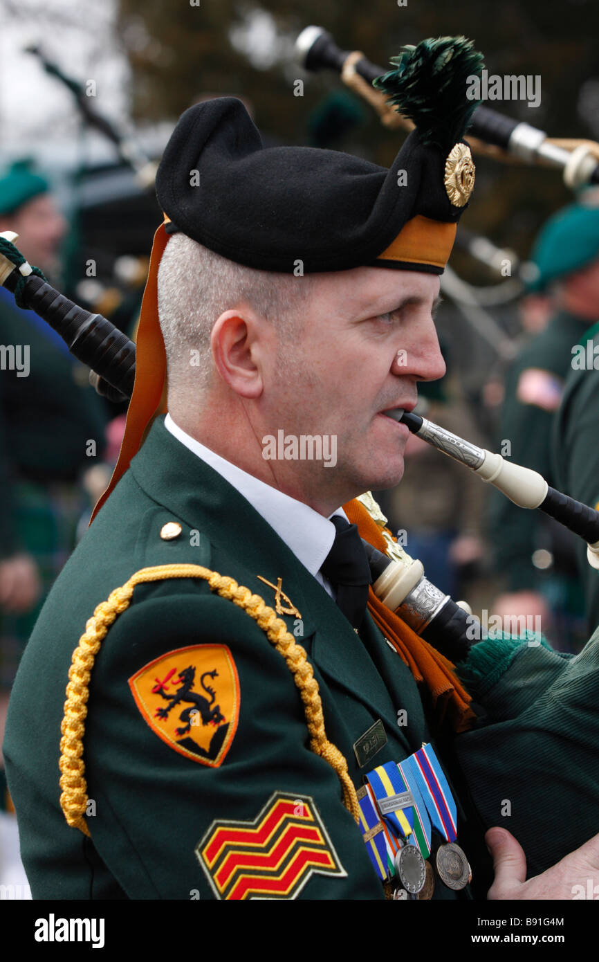 Member of Ancient Order of Hibernians plays the bagpipes in St Patrick's Day Parade Stock Photo