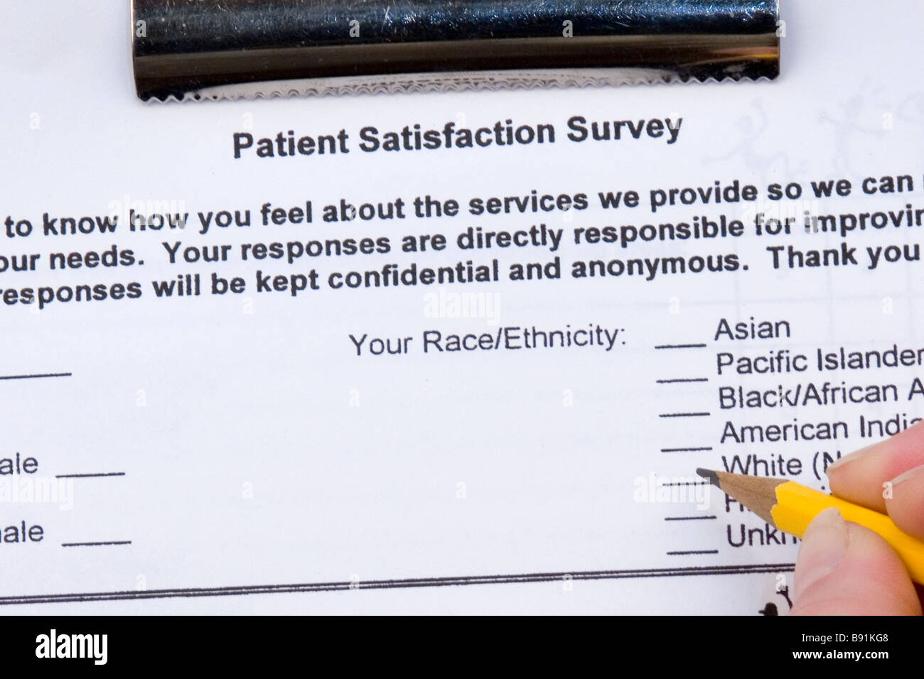 A patient fills out a patient satisfaction survey at a doctor's office. Stock Photo