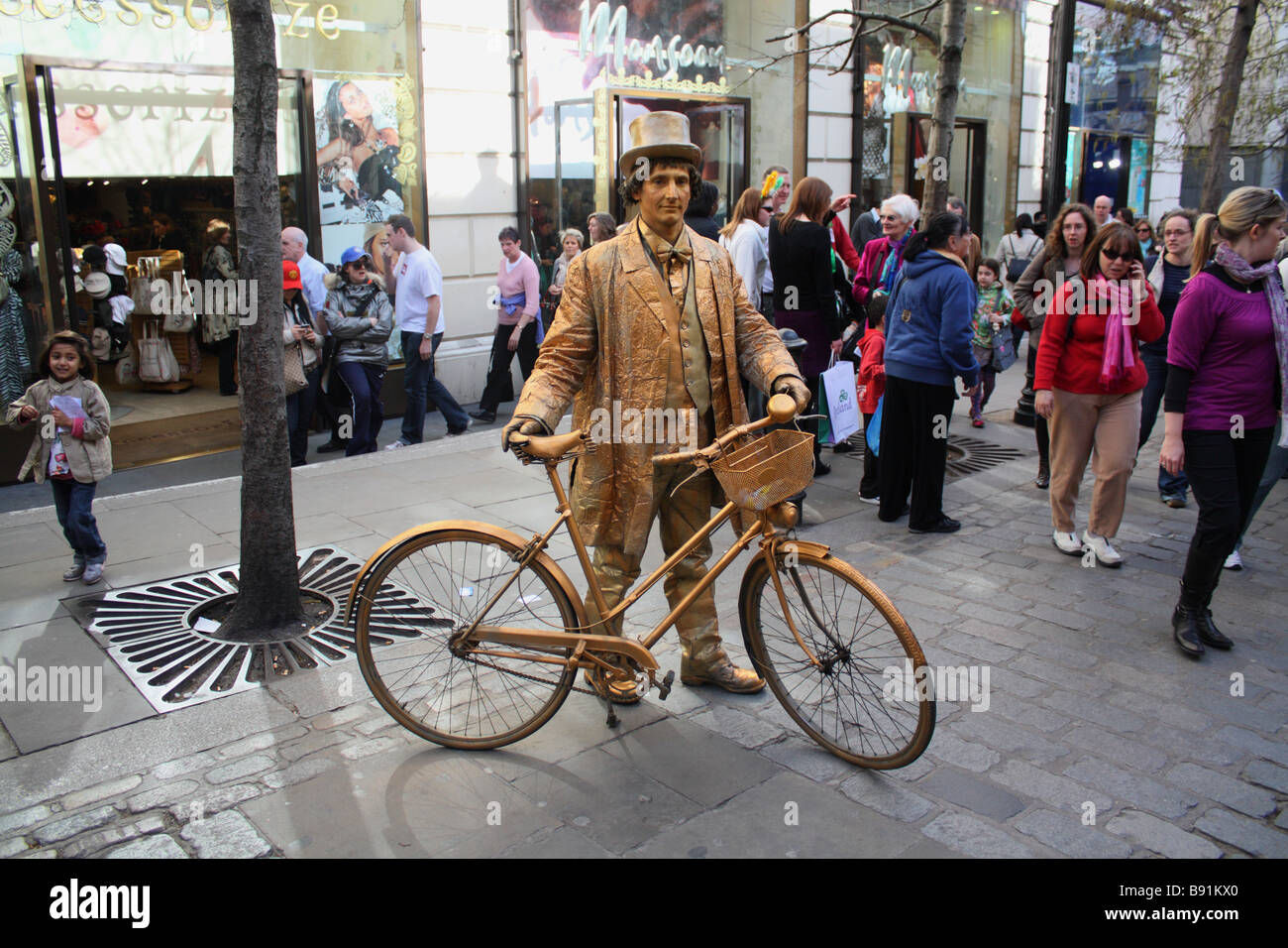 Bronze man human statue street performer with bicycle Covent Garden. Stock Photo
