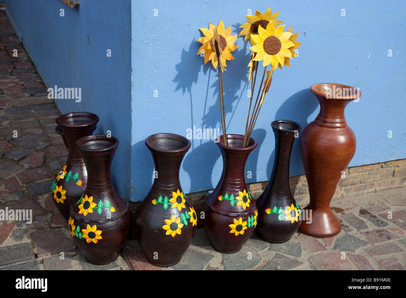 Colourful pots and wooden sunflowers for sale in the Colombian village