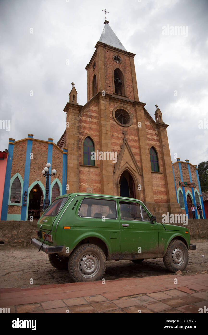 Green car parked in front of church on main square of the Colombian village of Raquirá Stock Photo