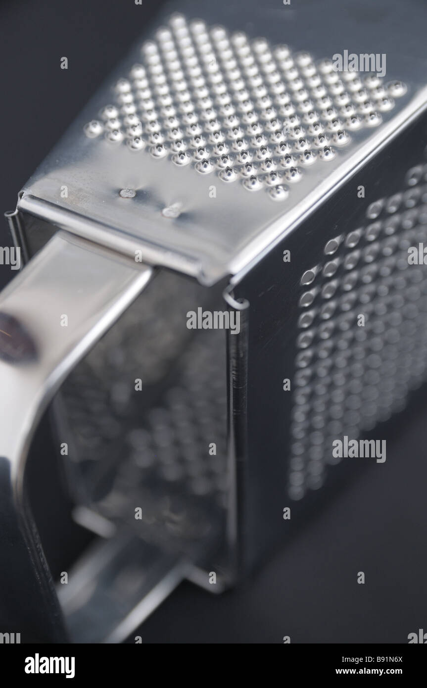 https://c8.alamy.com/comp/B91N6X/a-stainless-steel-box-grater-shredder-against-a-black-backdrop-with-B91N6X.jpg