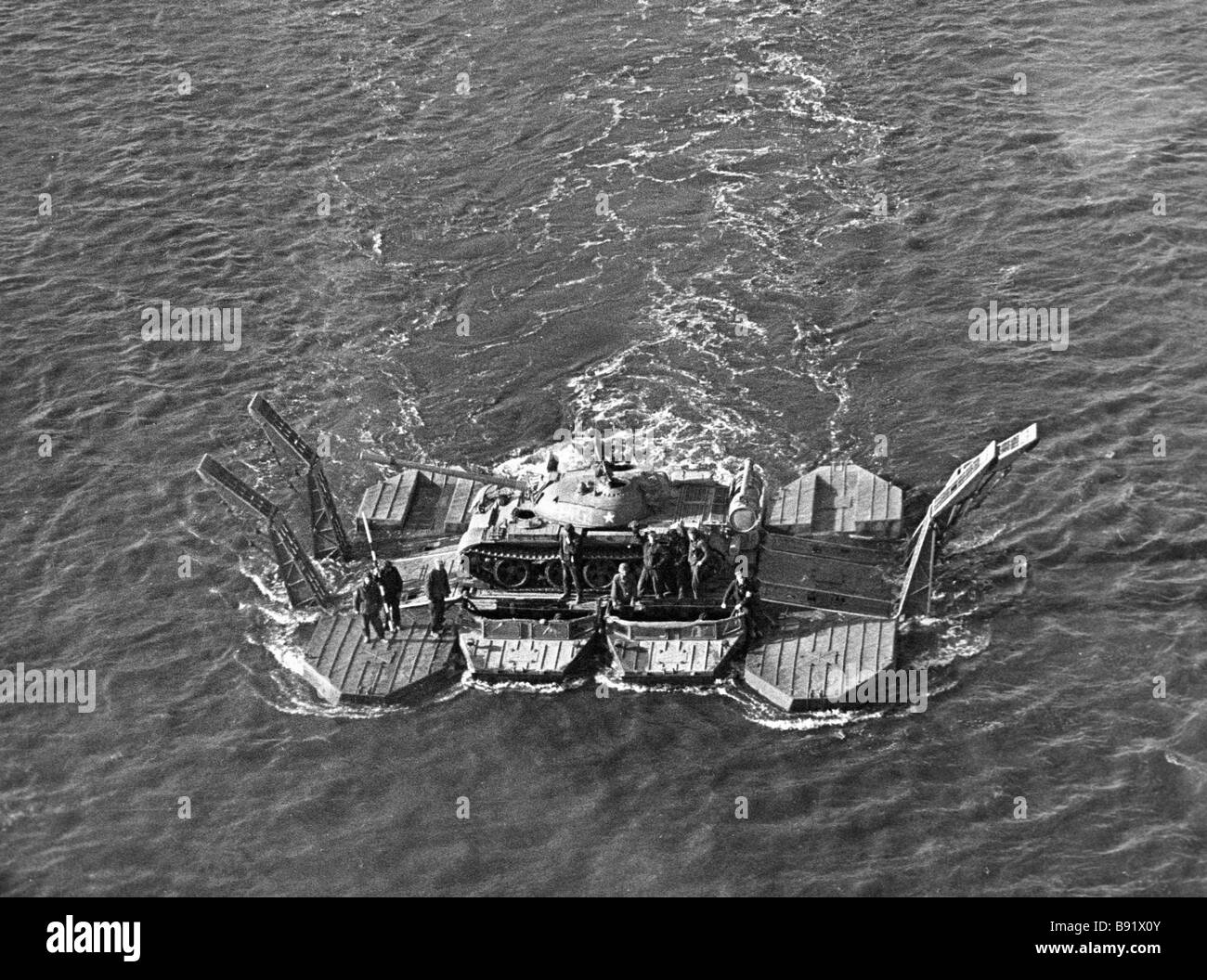 Soldiers carry a tank over a water obstacle on a pontoon Stock Photo