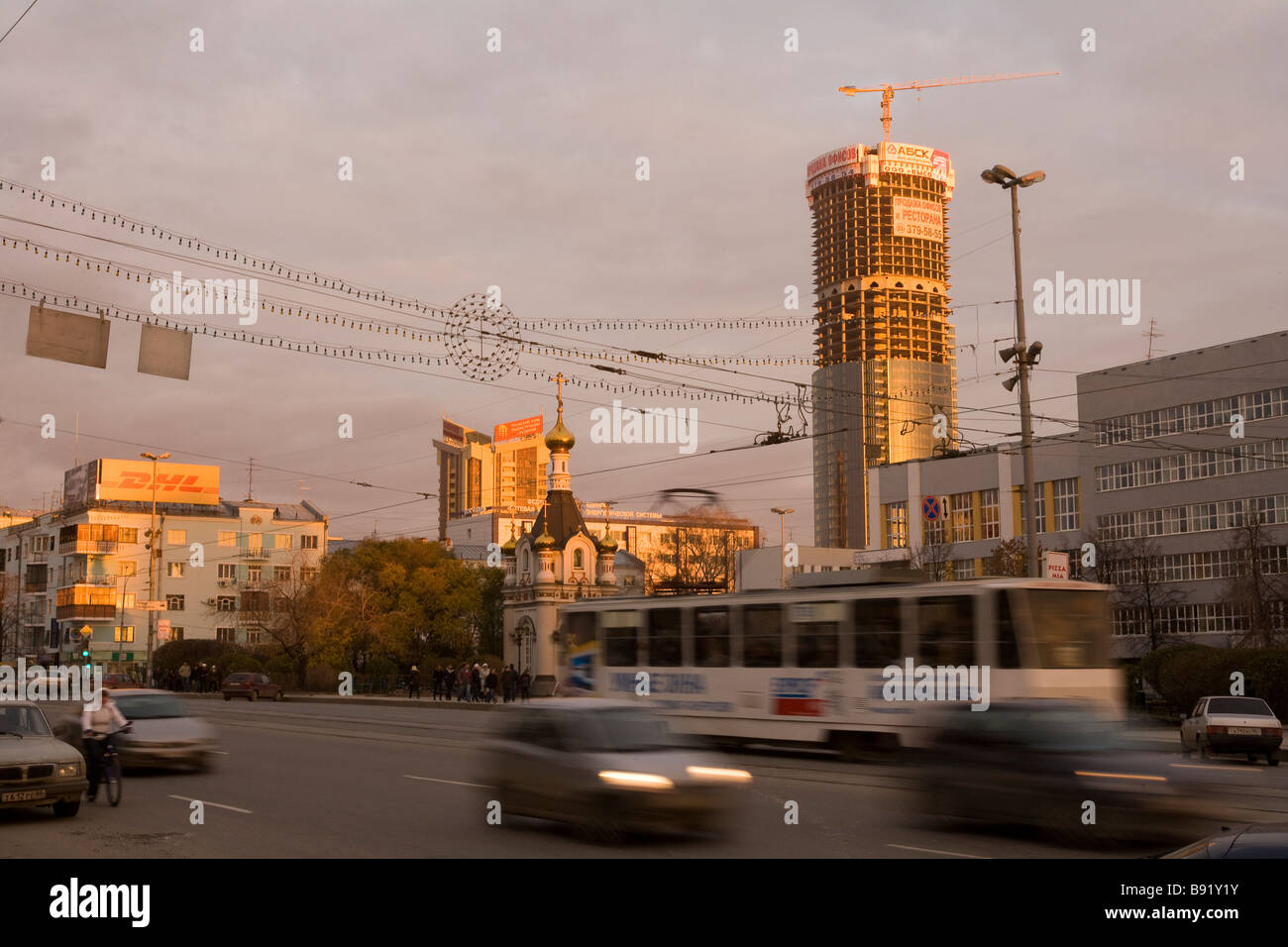 Street scene with busy traffic below construction crane on new skyscraper, Ekaterinburg, Russia Stock Photo