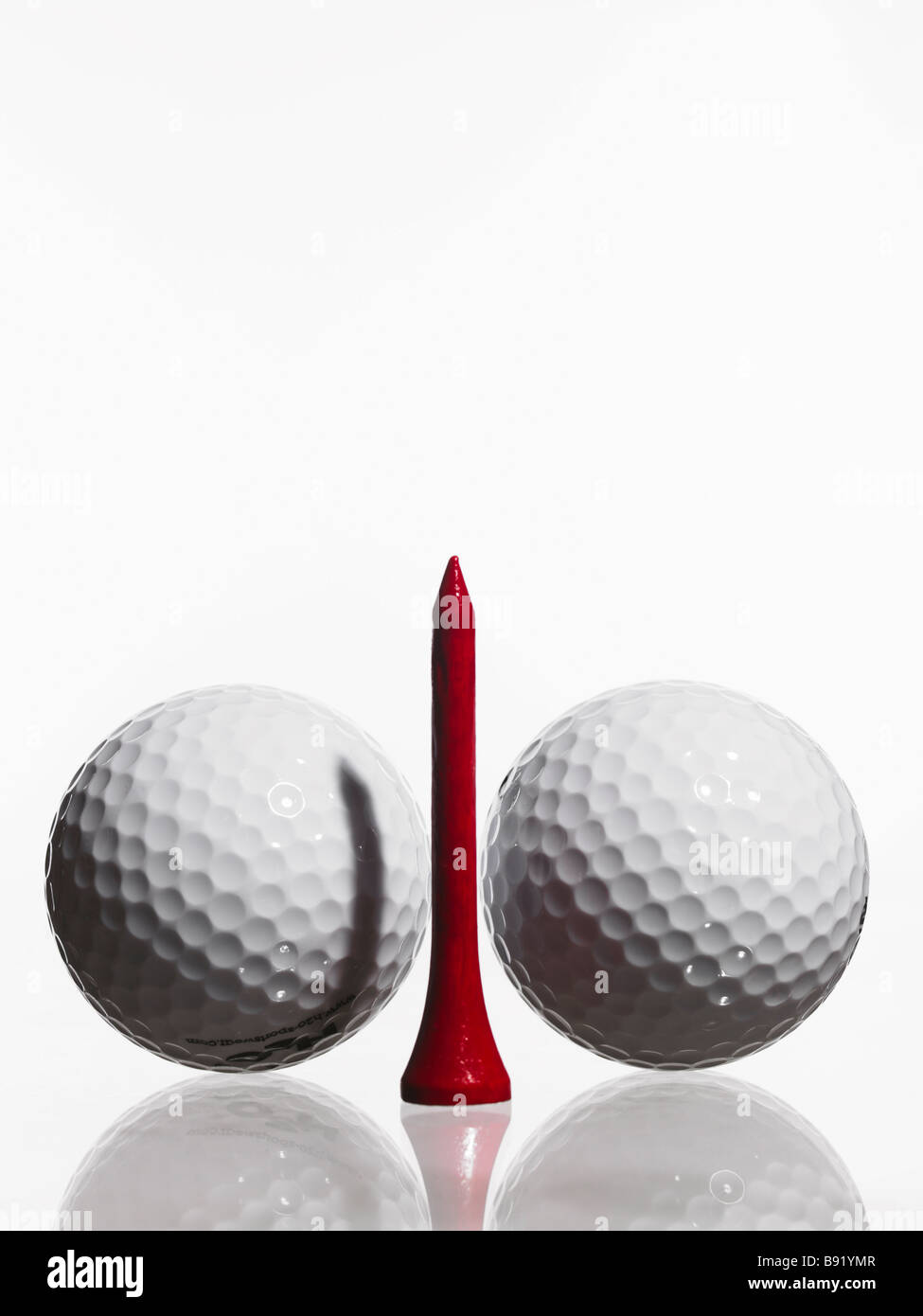 Two golf balls and a tee Stock Photo - Alamy