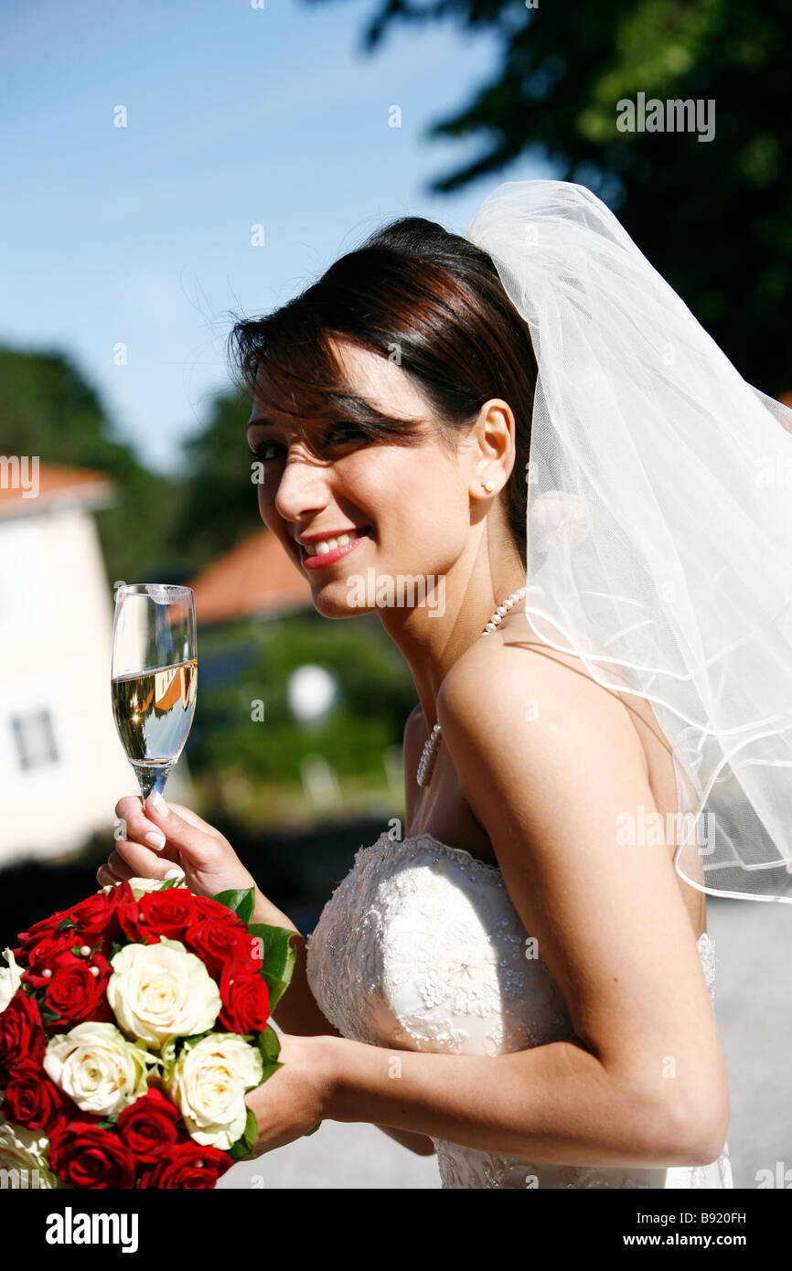 A smiling bride holding a glass of champagne Sweden. Stock Photo