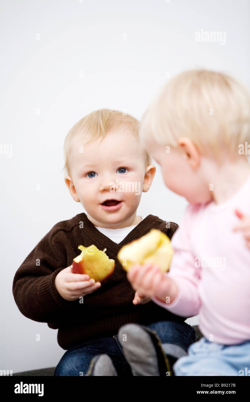 Two babies holding apples Sweden. Stock Photo
