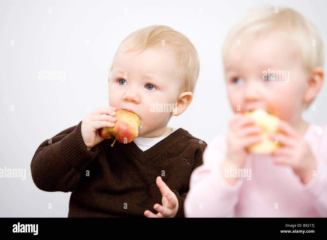 Two babies holding apples Sweden. Stock Photo