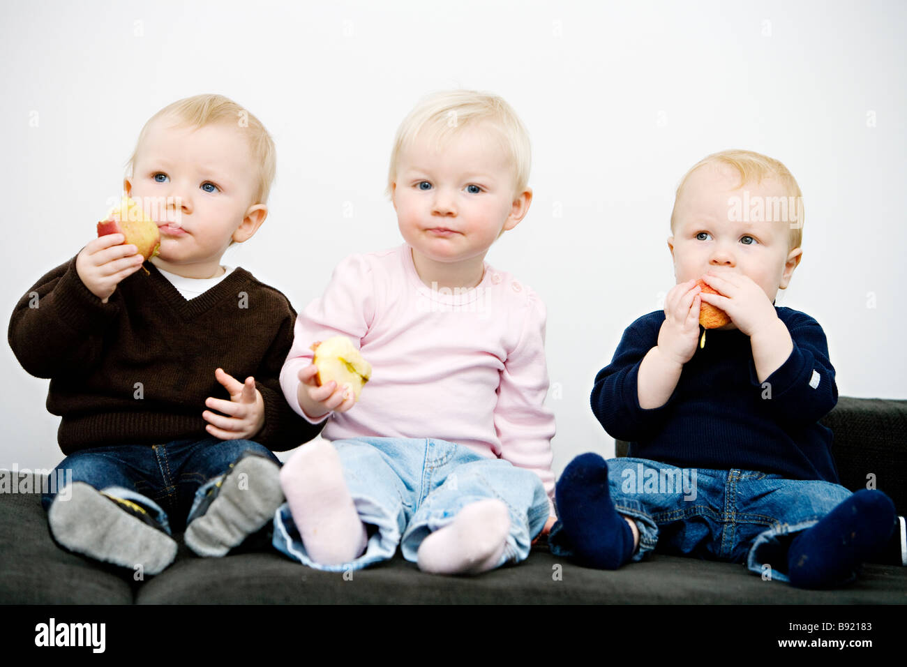 Three children holding apples Sweden. Stock Photo