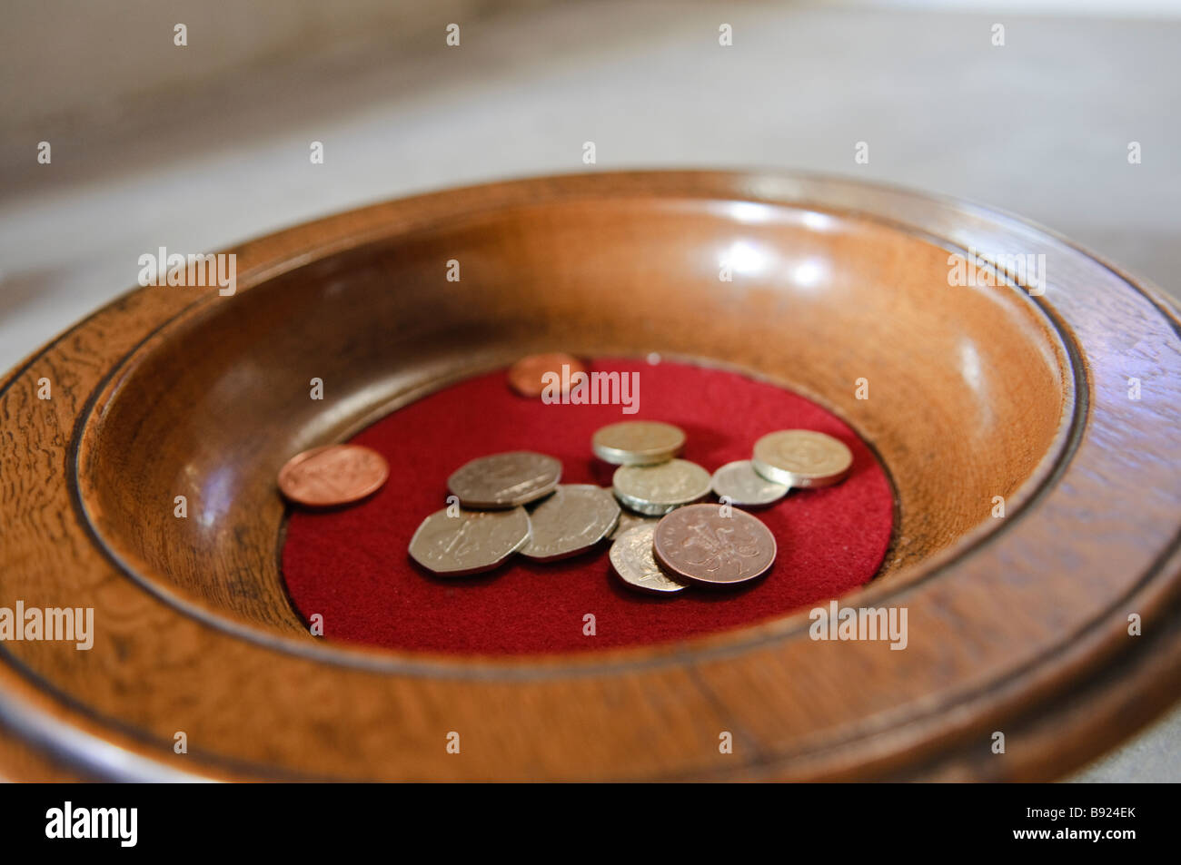 Church collection bowl with some UK Coins Stock Photo