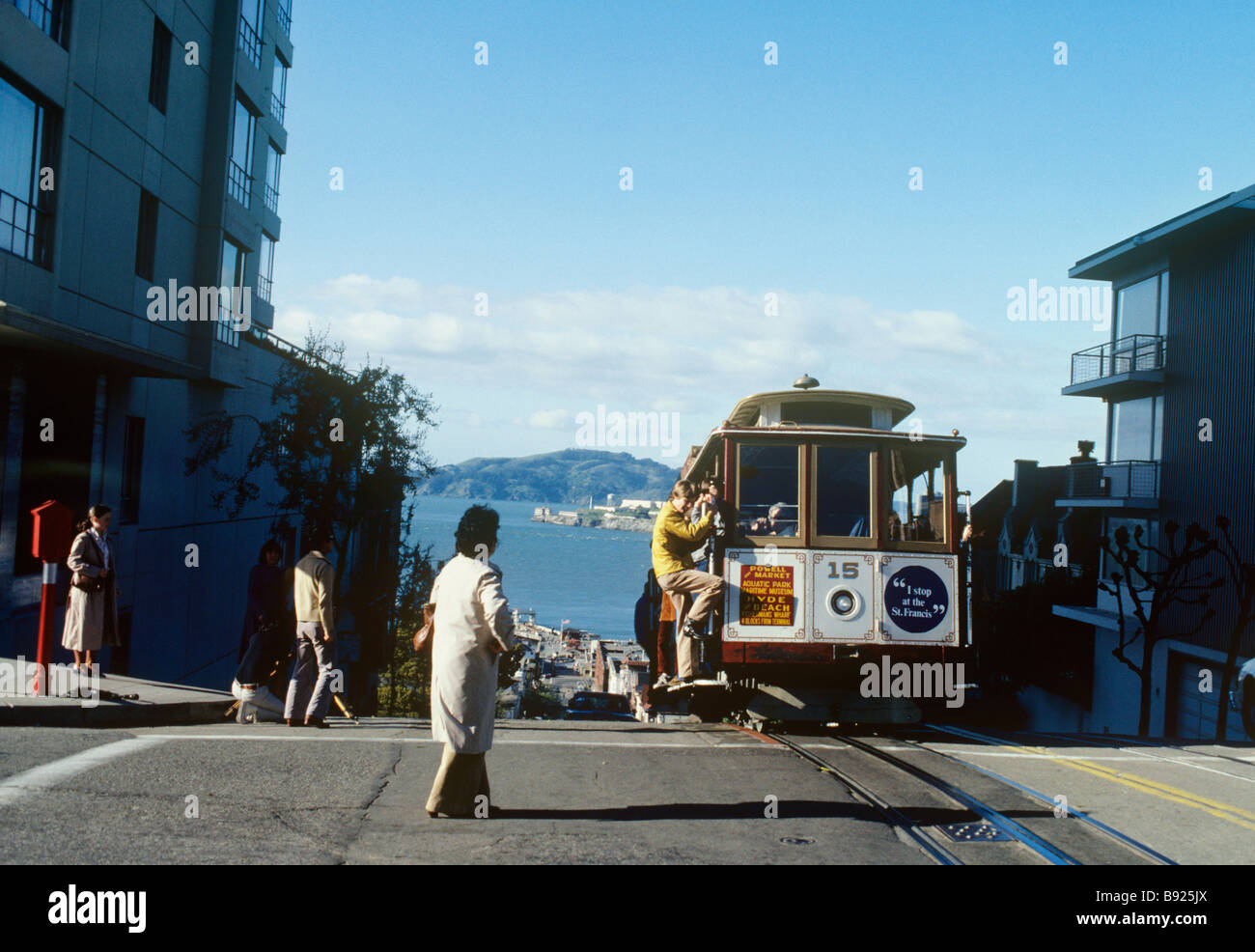 SanFranciscoU.S.A.A cable car comes to the top of a hill, with a view beyond of Alcatraz.There are 3 braking systems to each car Stock Photo