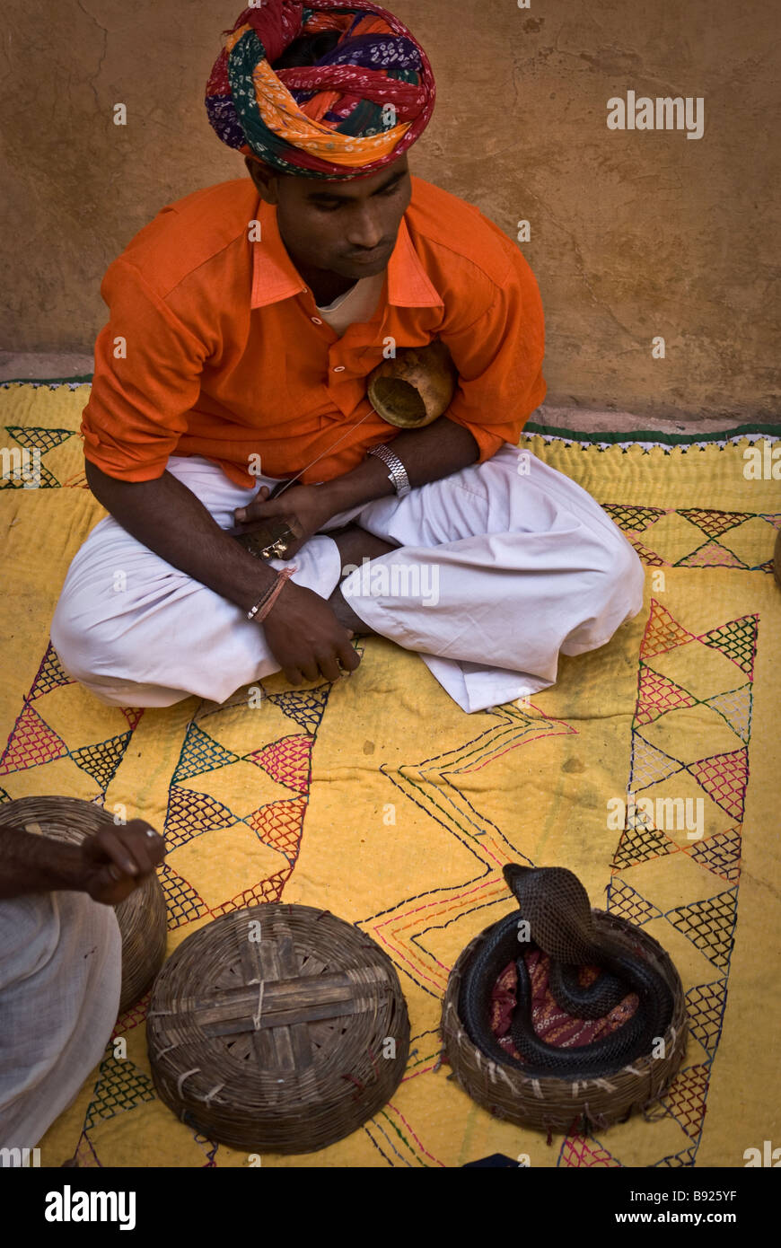 A snake charmer performing in front of interested tourists. India. Stock Photo