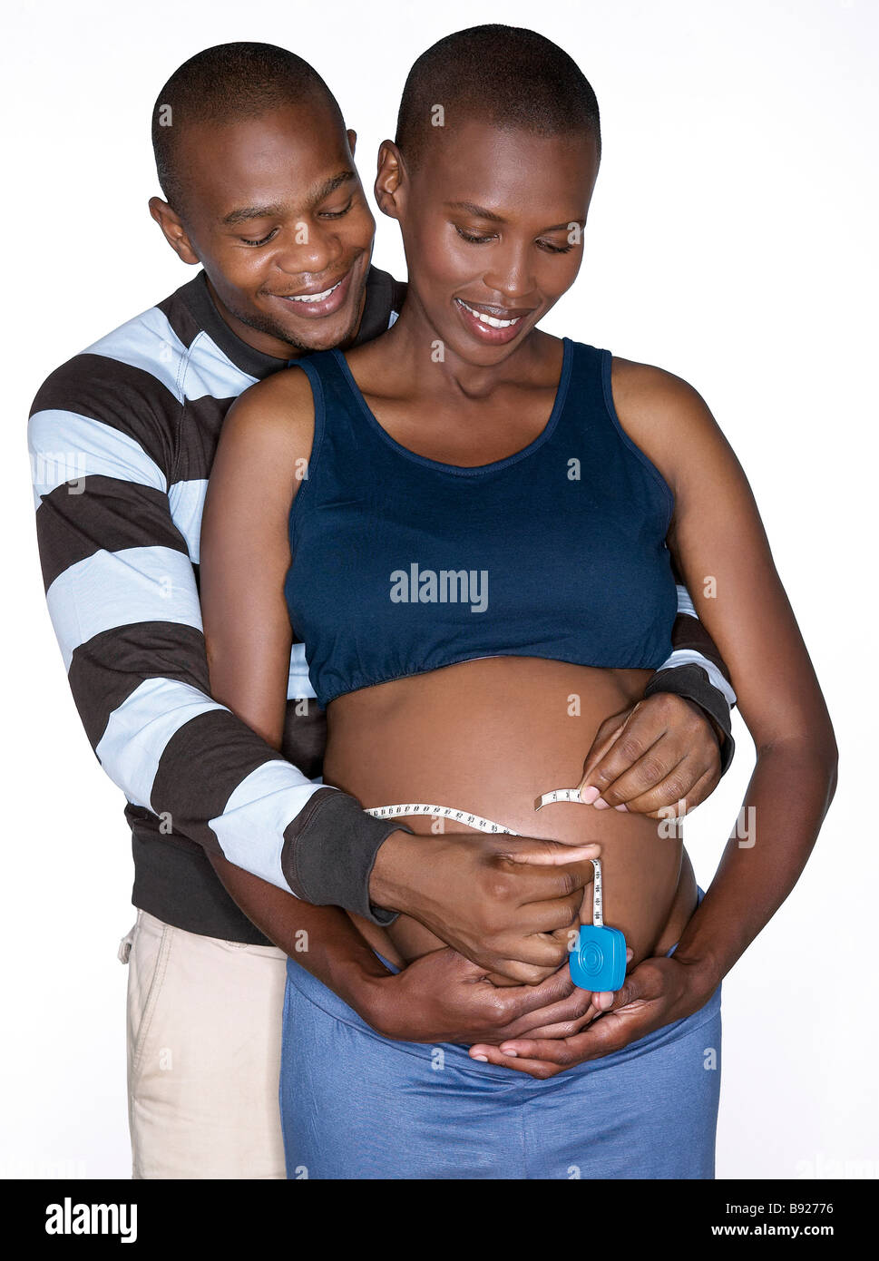 High angle view of pregnant woman and partner measuring her tummy Studio Shot Stock Photo