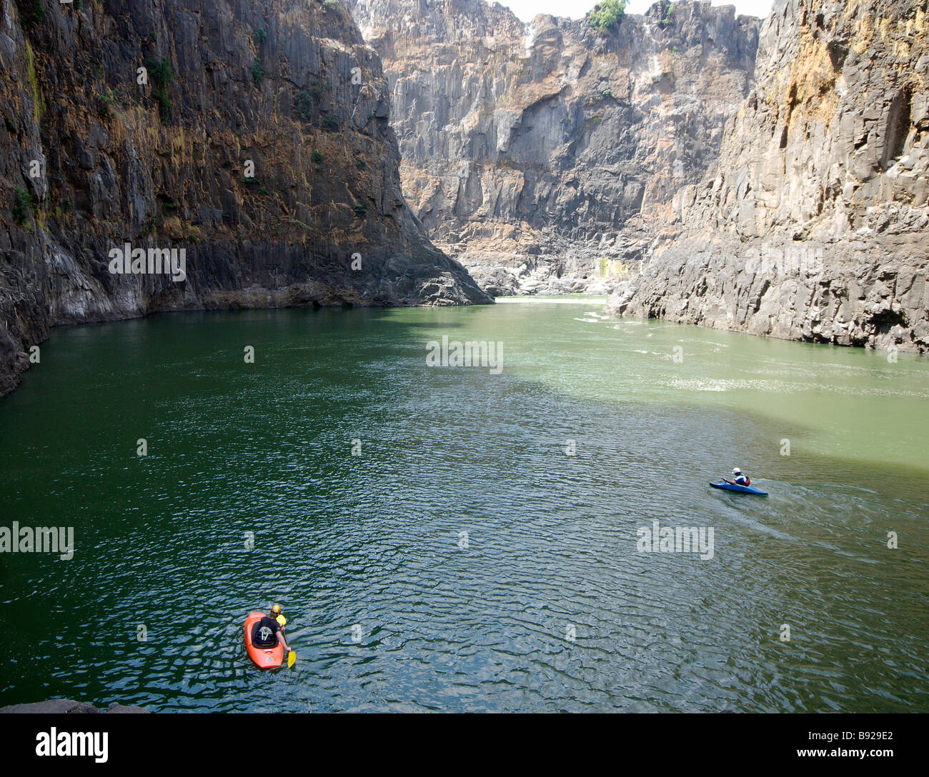 Two kayakers begin paddling upstream on the Zambezi river Victoria Falls Matabeleland North Zimbabwe Stock Photo