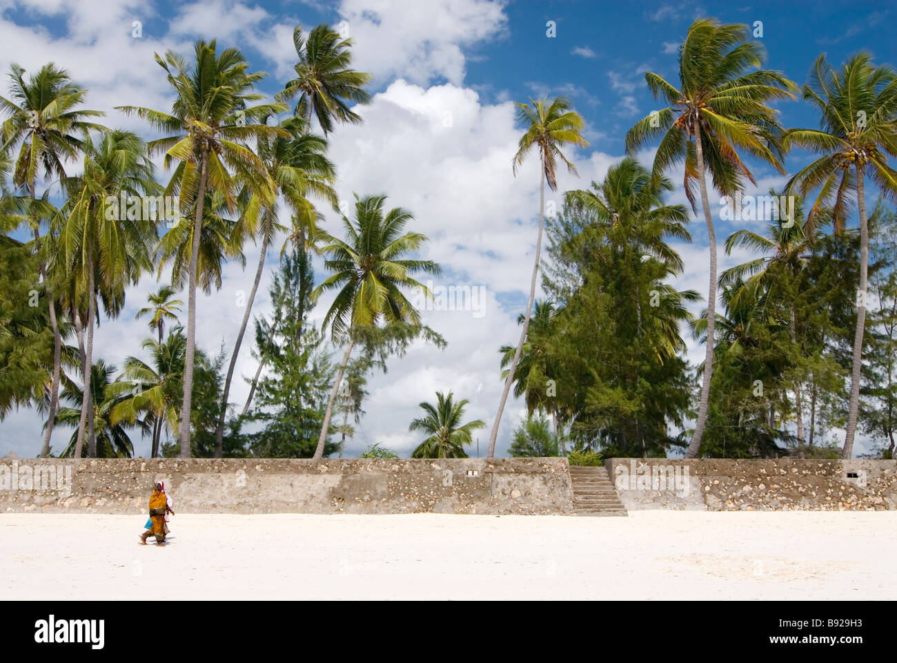 Two local women wearing kikois walking along the beach, Zanzibar Island Paje Unguja Island Zanzibar Tanzania Stock Photo