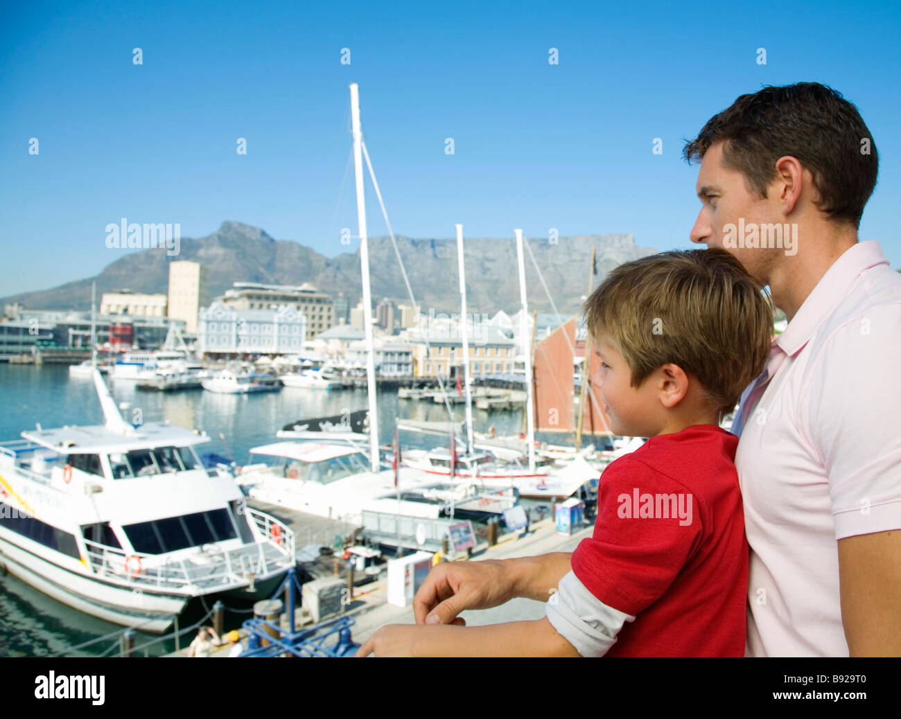 Young boy and his father looking out at boats from Waterfront, Cape Town, Western Cape Province, South Africa Stock Photo