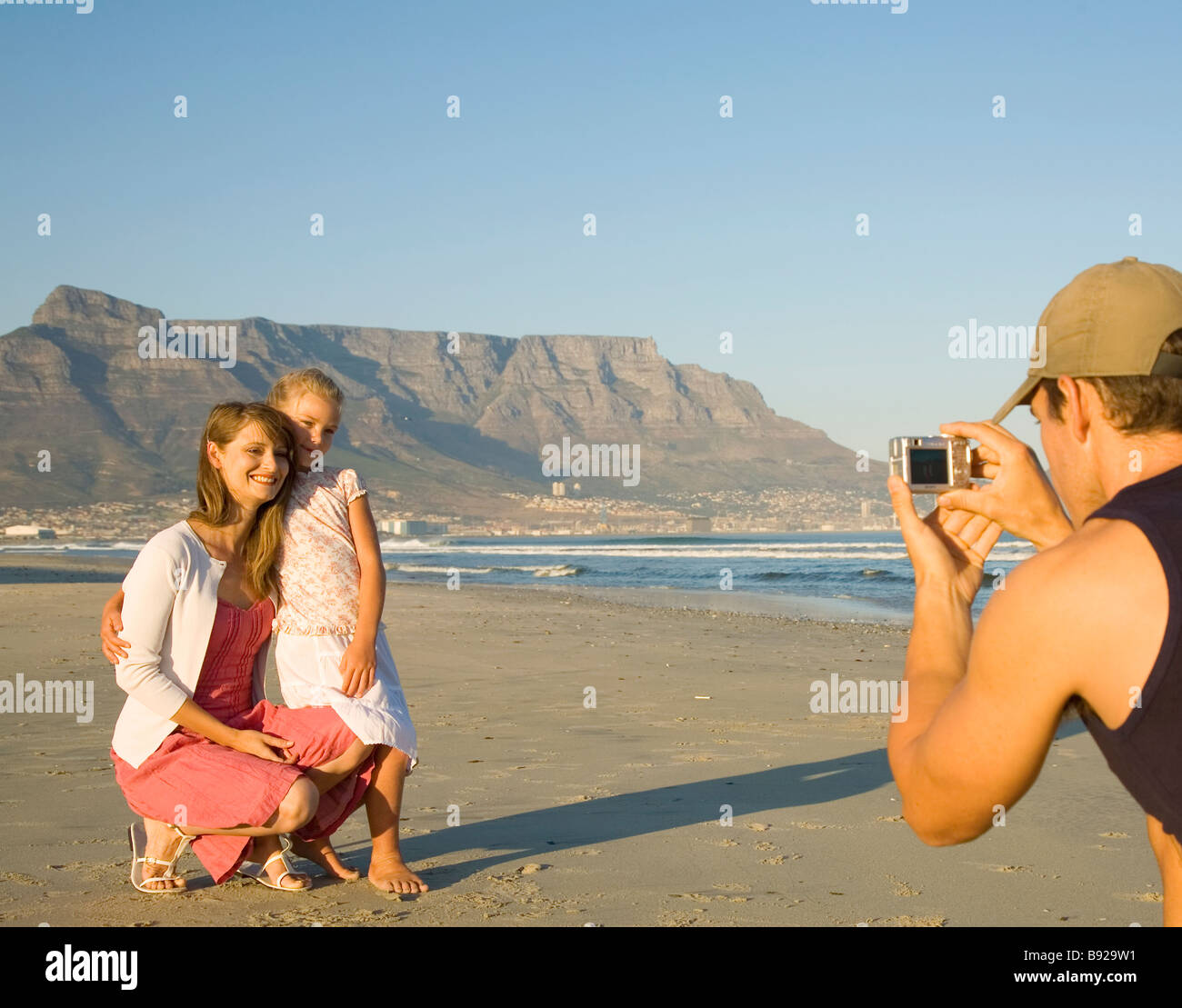 Man taking photograph of mother and daughter posing Cape Town Western
