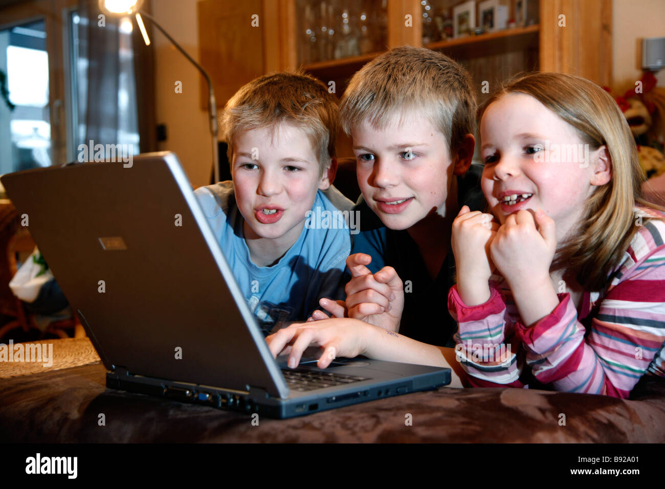 2 brothers and her sister, 7, 11 and 13 years old, playing a learning