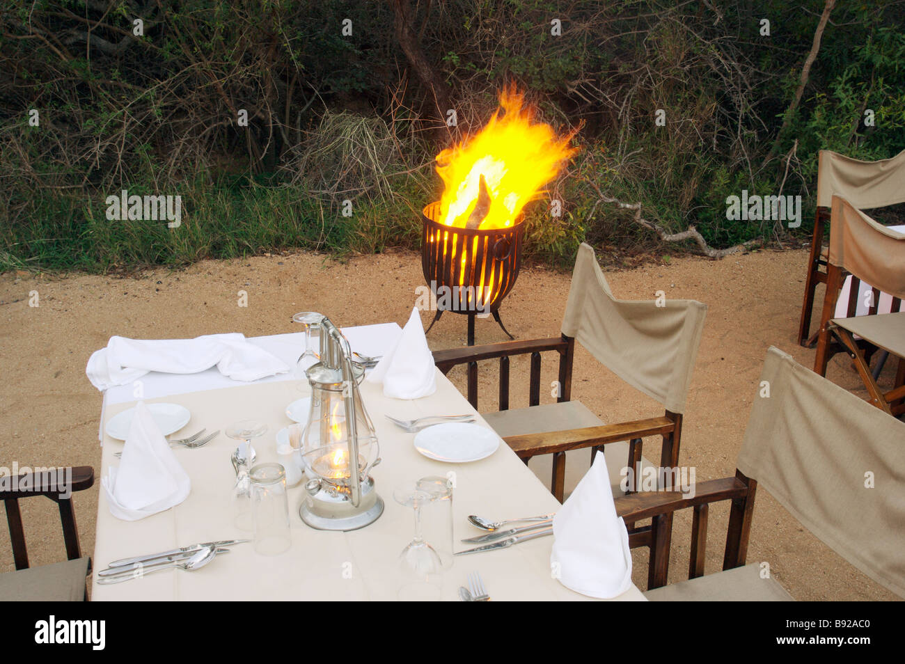 View of table set up for meal with fire next to table Kapama Lodge Limpopo Province South Africa Stock Photo