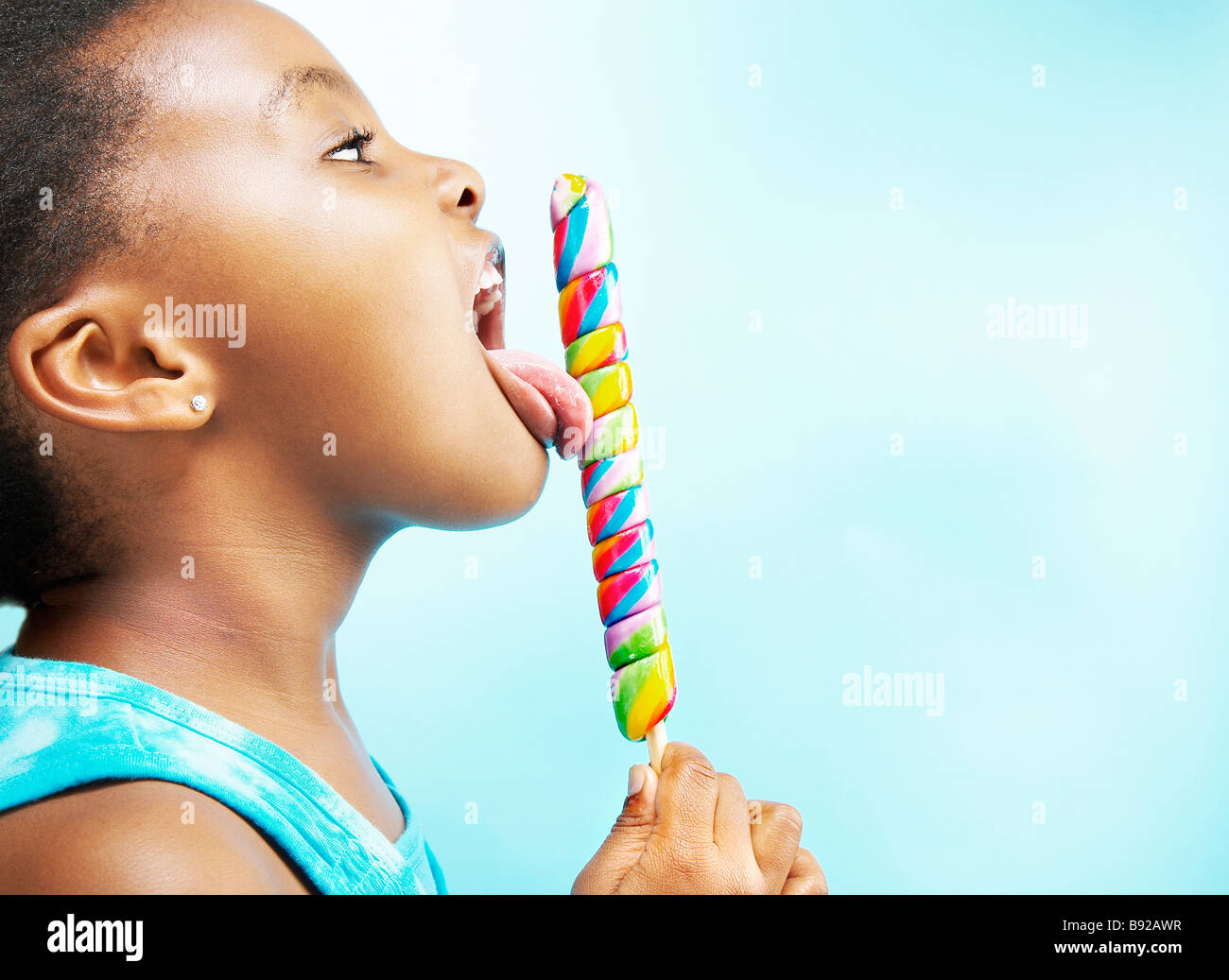 Side view of young girl licking lollipop Stock Photo