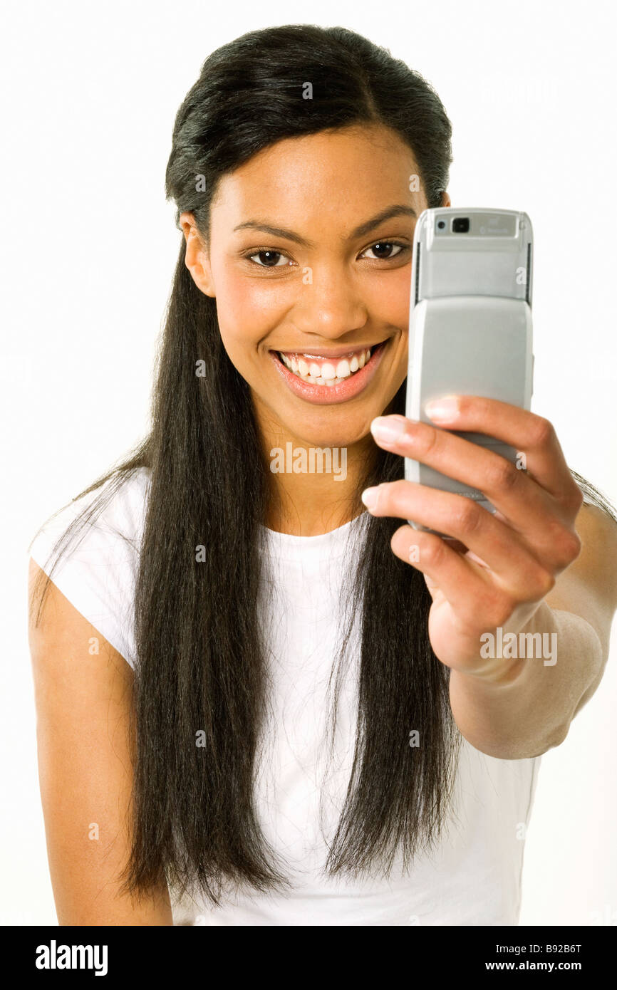 Studio shot of Young girl taking picture using mobile phone Stock Photo