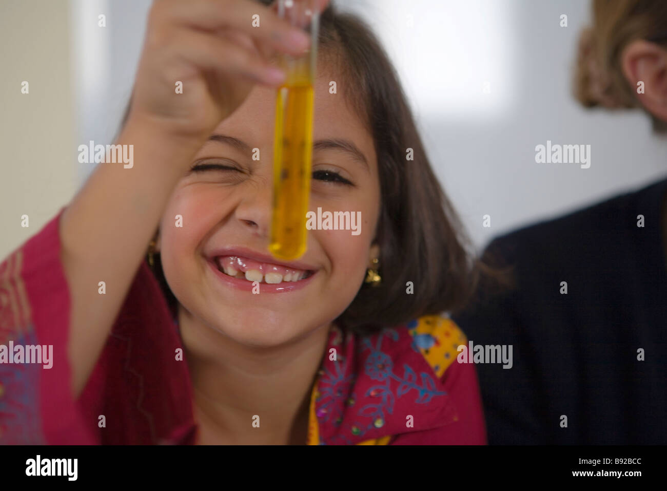 Young girl looking at a test tube in a chemistry science class Dubai United Arab Emirates Stock Photo