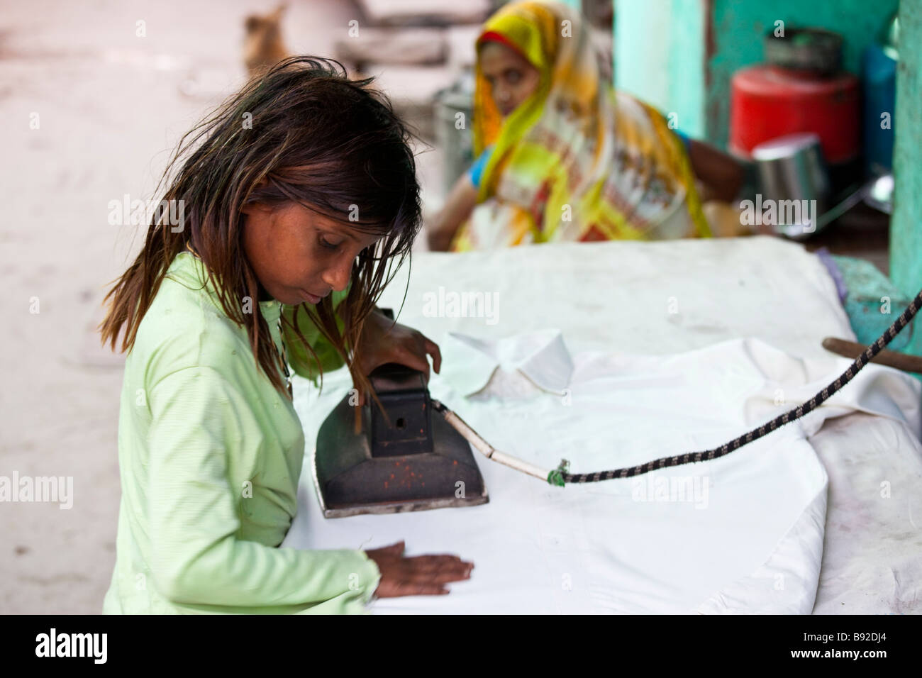 Young Indian Girl Working at a Laundry Ironing Clothing in Fatehpur Sikri India Stock Photo