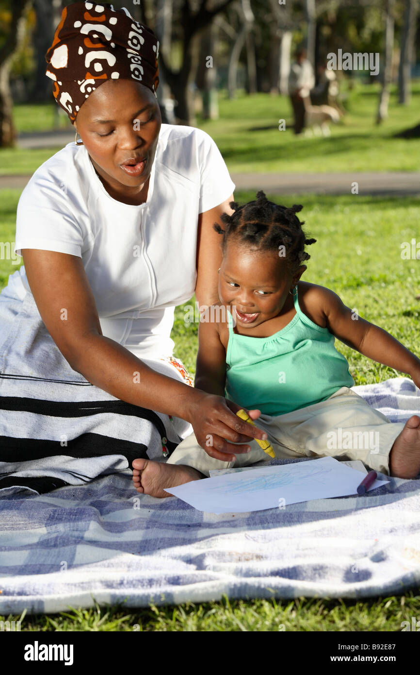 Mother showing her daughter how to draw in the park Dewaal Park Cape