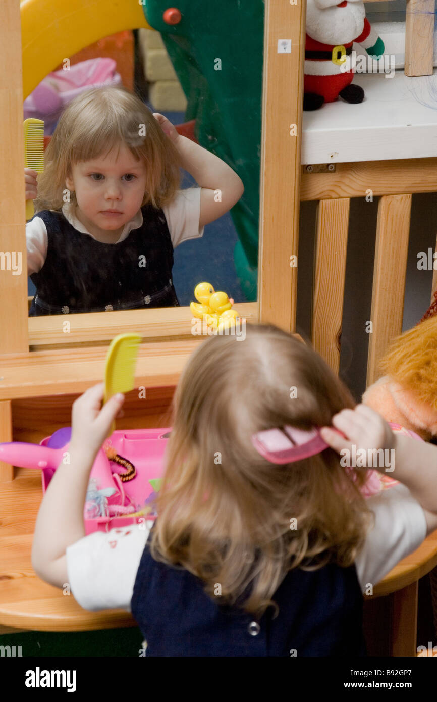 Two Year Old Girl Combing Hair Stock Photo
