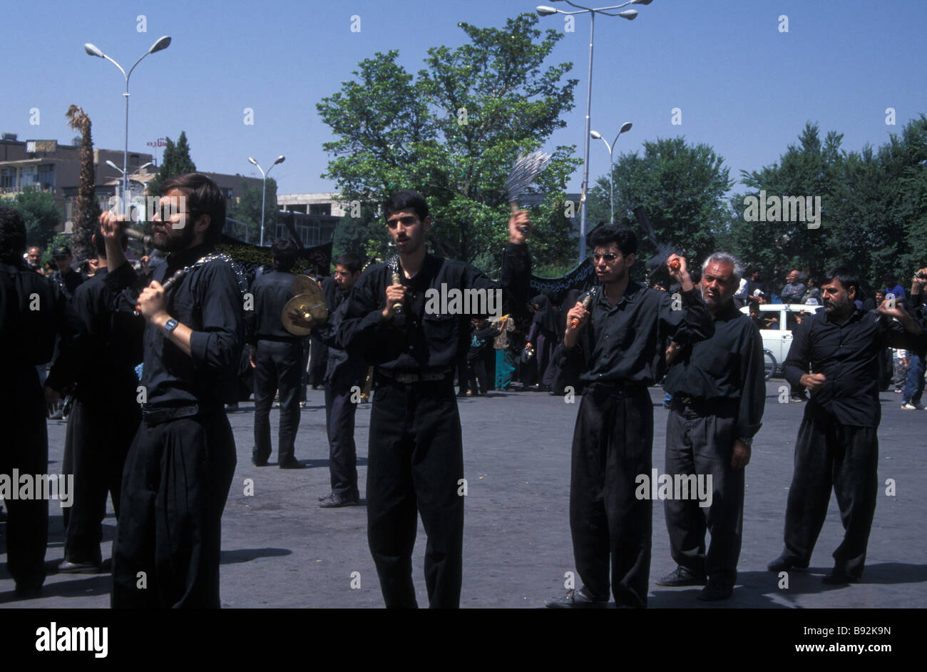 black clothed Shia Shiite Islamic religion Iranian custom Muslim Muslims Muharam mourners self flagellating Isfahan Iran Stock Photo