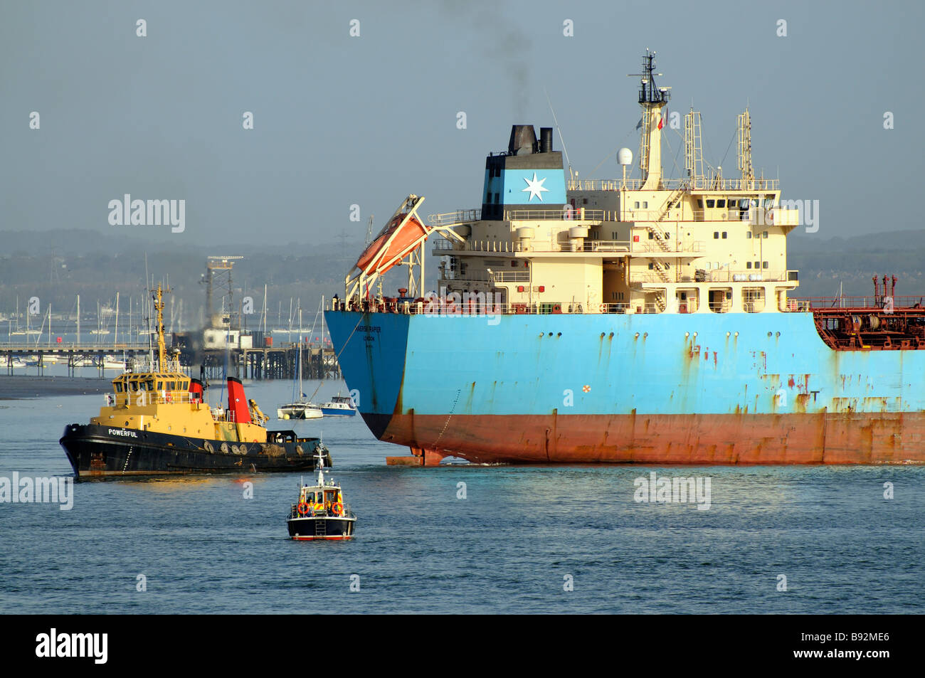 Maersk Rapier product oil tanker ship with SD Powerful tug departing a fuel jetty on Portsmouth Harbour Hampshire England UK Stock Photo