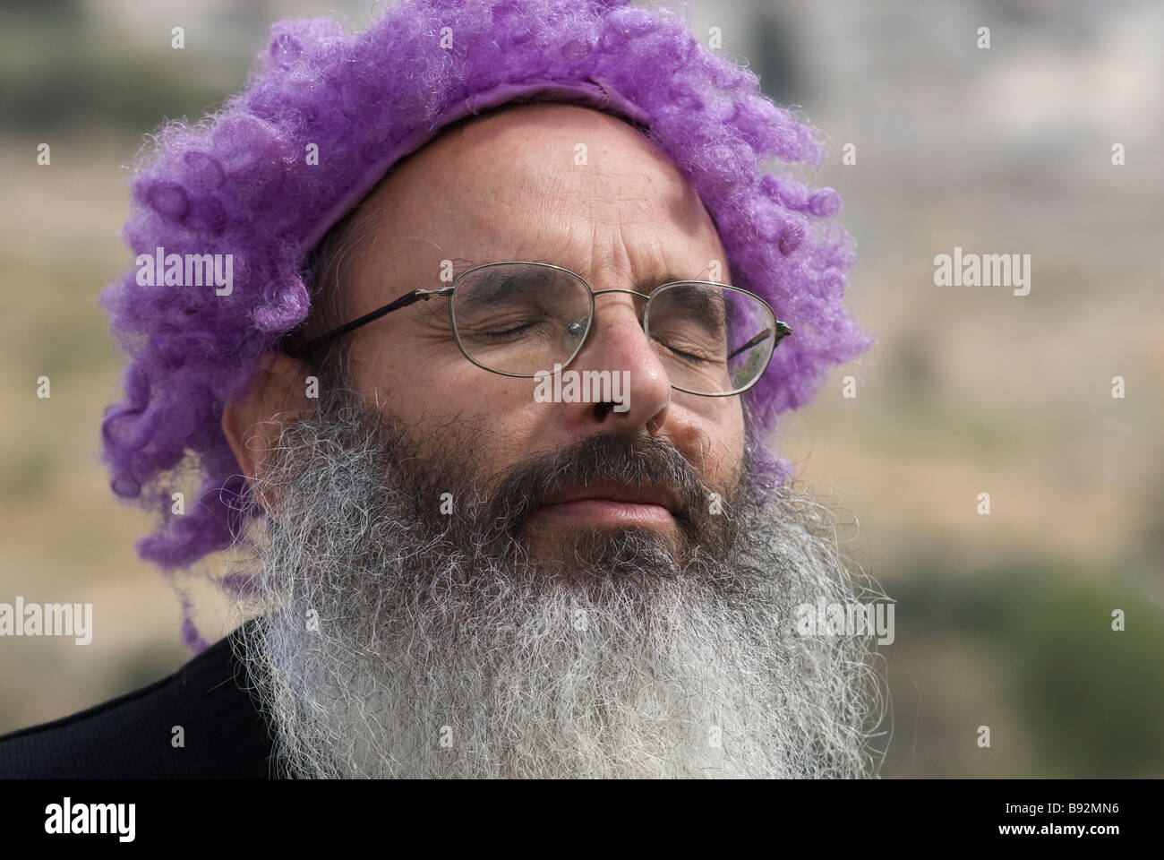 A Jewish settler wears a purple costume during the annual parade marking the holiday of Purim in the old city of Hebron West bank Israel Stock Photo