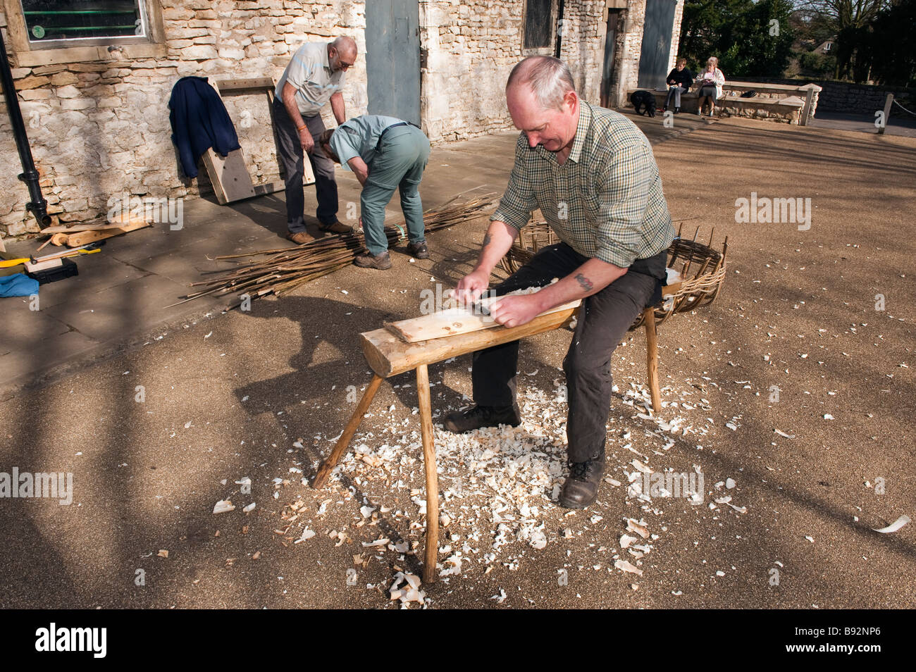 Coracle maker planing a flat length of timber Stock Photo