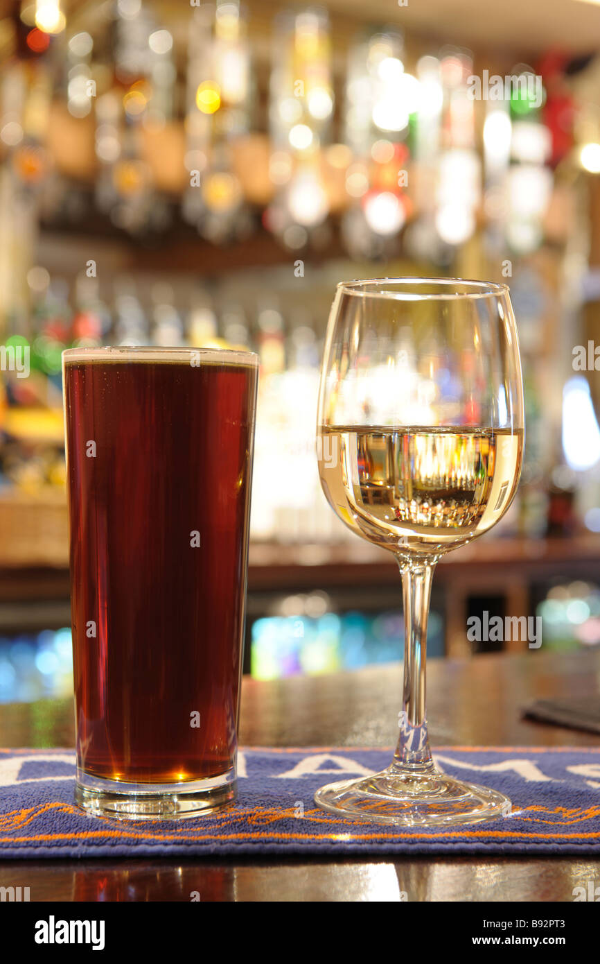 pint of beer and glass of white wine on bar in a pub Stock Photo
