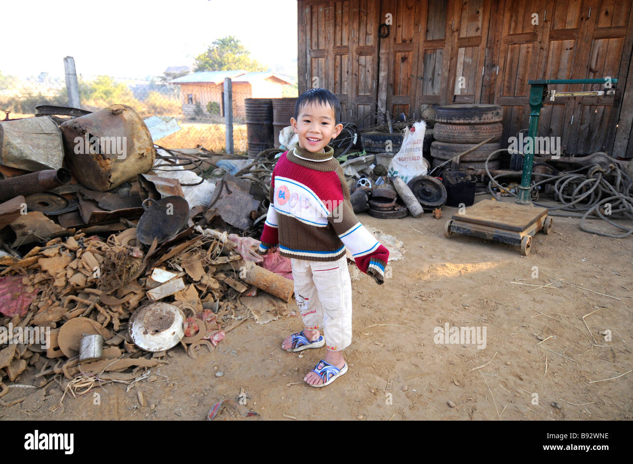 A young boy in front of his home where his parents purchase bomb scrap from metal hunters in Phonsavan Laos Stock Photo