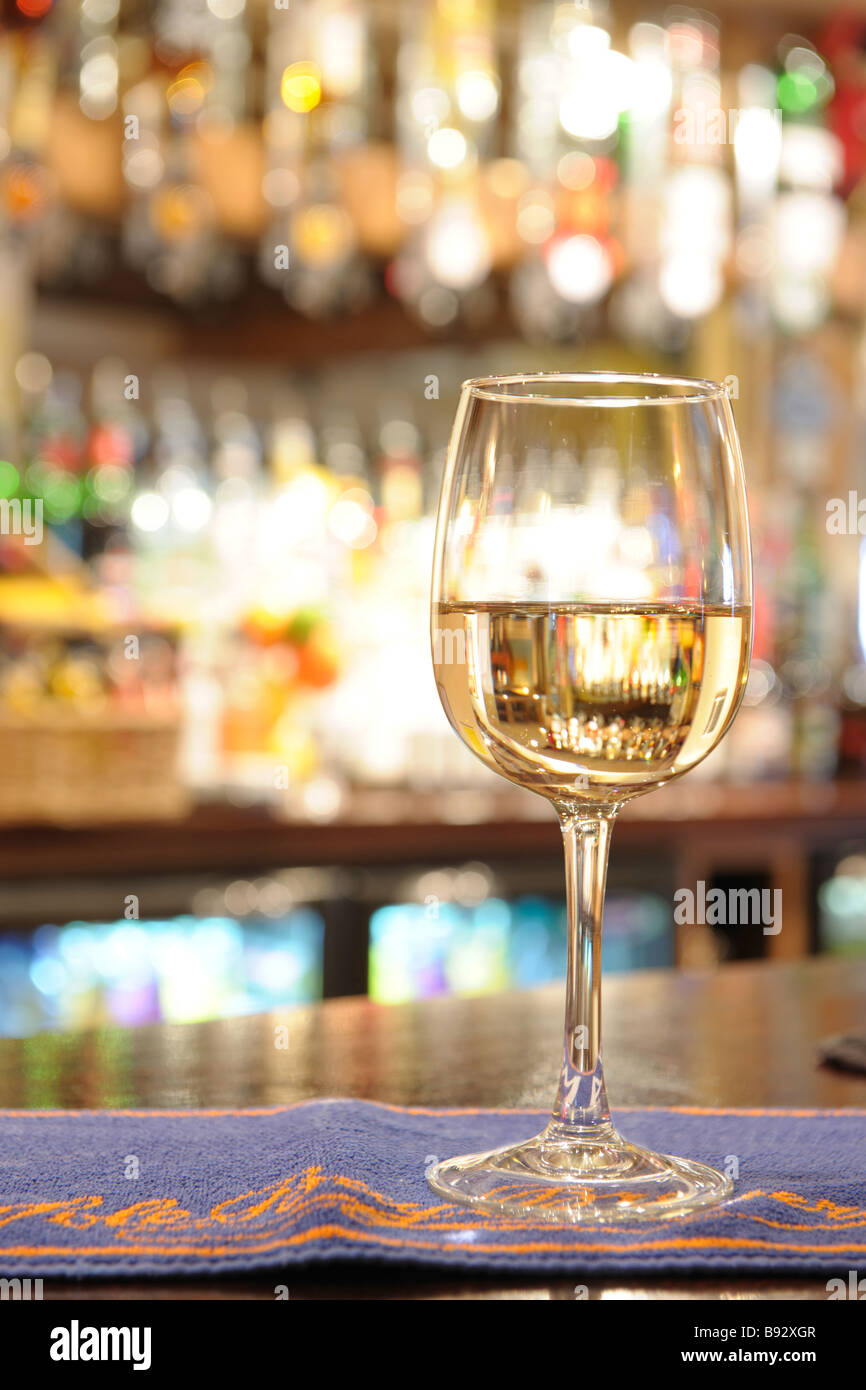 glass of white wine on a bar inside a pub Stock Photo