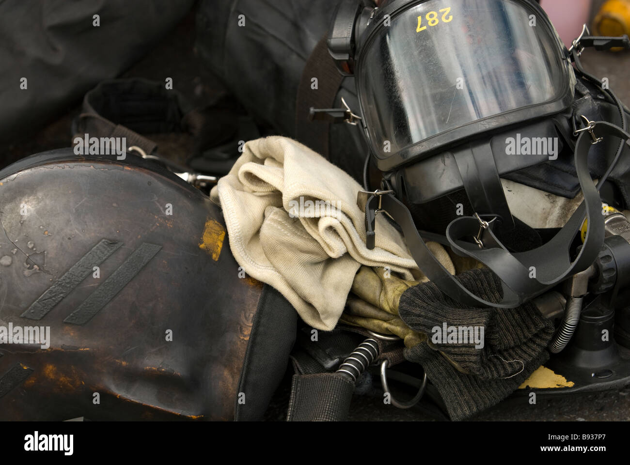 Fireman's helmet, Breathing Apparatus face mask and flash hood burnt black with fire Stock Photo
