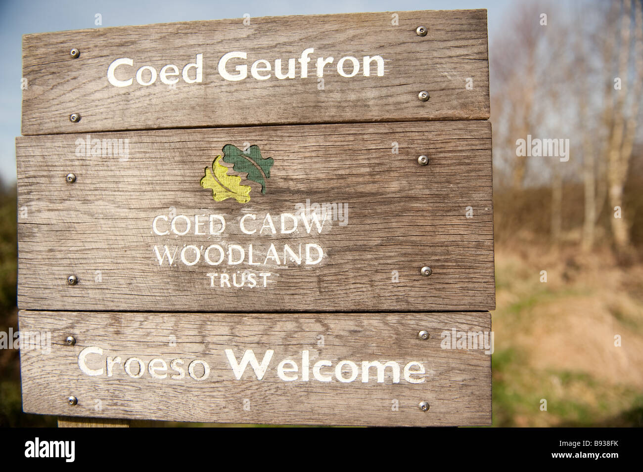 bilingual welsh english language sign at Coed Geufron woodland trust nature reserve Ceredigion Wales UK Stock Photo